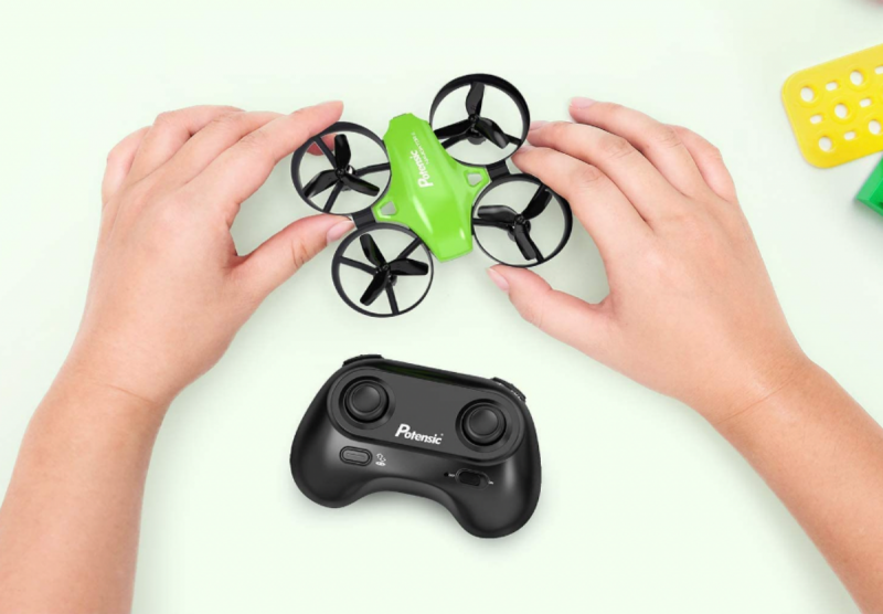   En Potensic A20 Mini Drone hålls i två händer för att visa sin lilla storlek