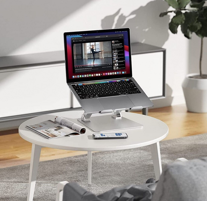   Nulaxy C1 bärbar dator står på ett bord i ett vardagsrum med ett magasin och en mobiltelefon vid basen