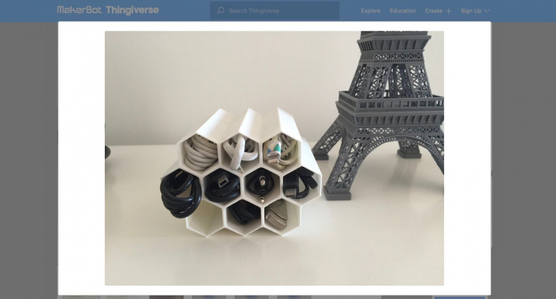   Kuvakaappaus Thingiverse-verkkosivustolta, jossa näkyy 3D-tulostettu hunajakennon muotoinen kaapelipidike.