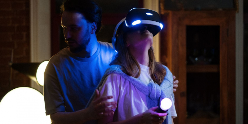   Bărbat o ajută pe femeie în timp ce ea joacă VR