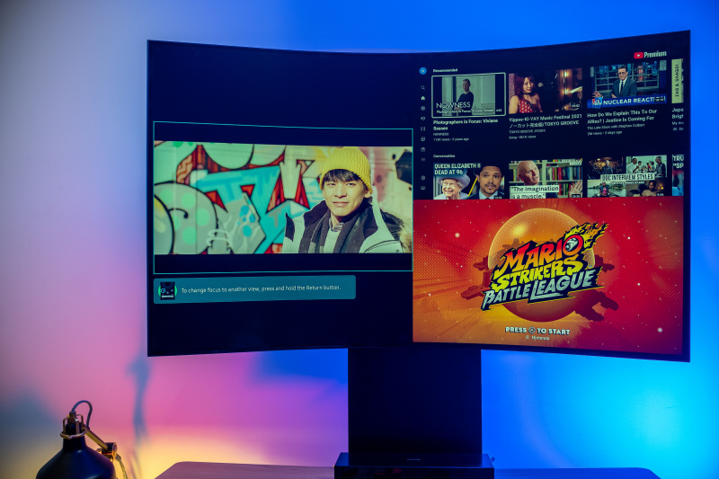   Samsung Odyssey Ark 55in în MultiView care arată un program TV în stânga, iar aplicația Youtube și Mario Strikers stivuite în dreapta