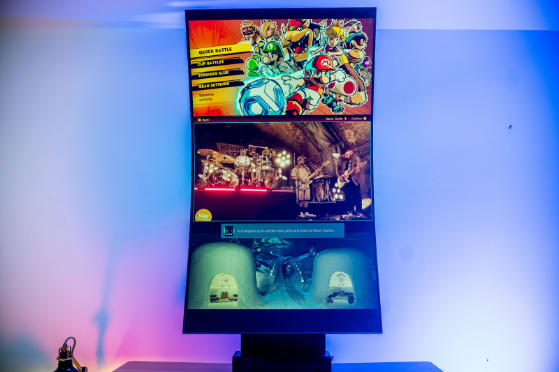   Samsung Odyssey Ark în modul Cockpit și MultiView care afișează un program TV în partea de jos, aplicația Youtube în mijloc și Mario Strikers în partea de sus a afișajului