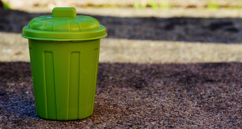   thùng rác nhỏ màu xanh lá cây trên mặt đất