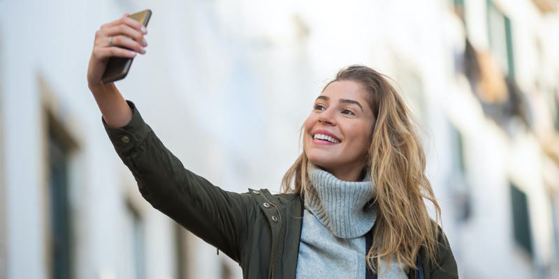   Una dona fent-se una selfie amb el seu telèfon intel·ligent