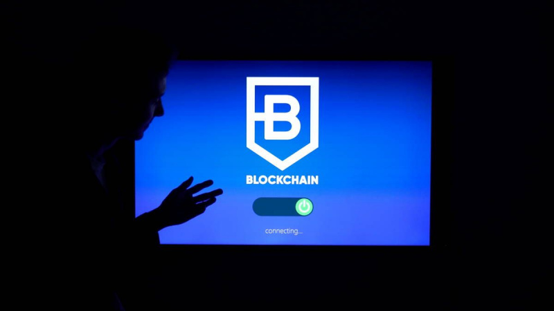   عرض الشاشة كلمة blockchain رجل واقف