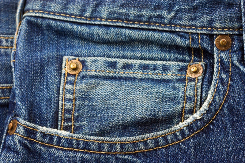   Een close-up van een jeanszak met koperen klinknagels